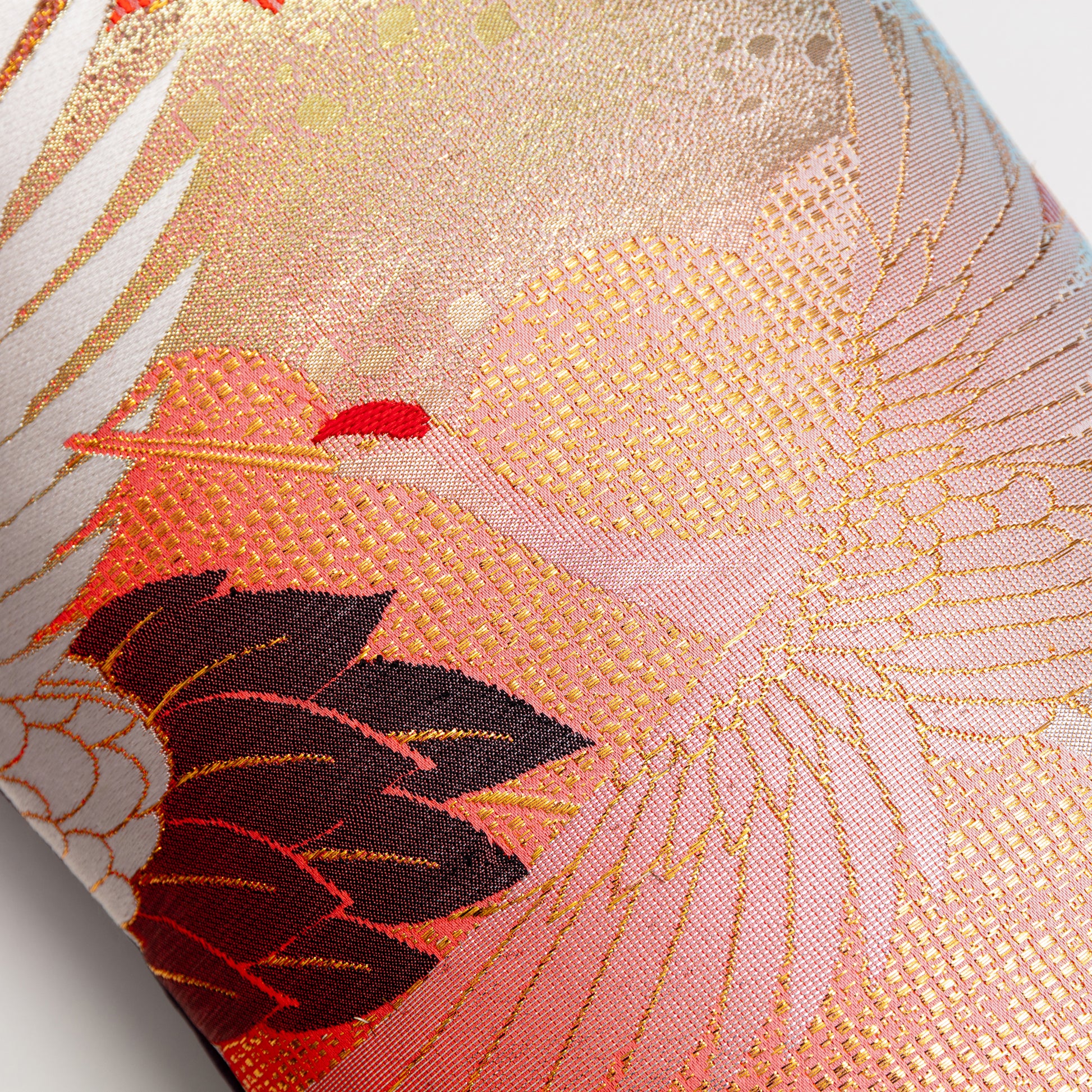 Detail of the front of the pillow showing a muted gold and orange flying crane over clouds.