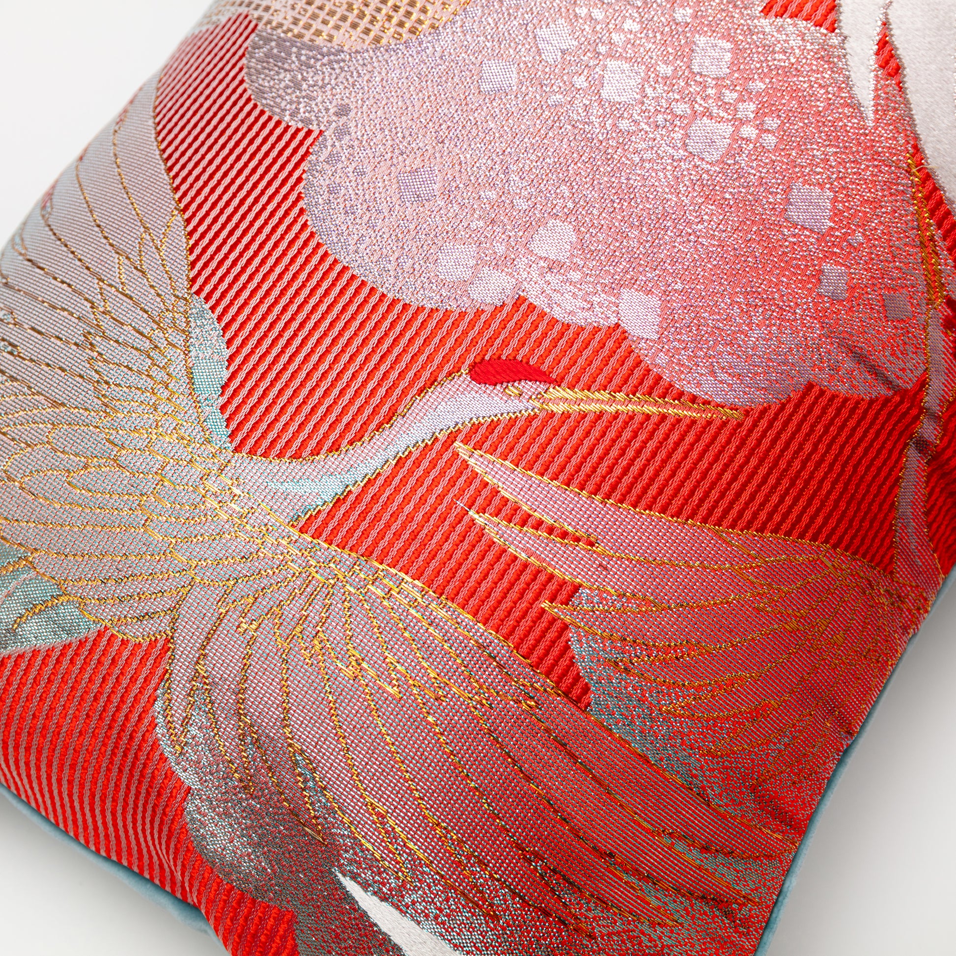 red pillow detail of flying crane in  gold over striped background silk.