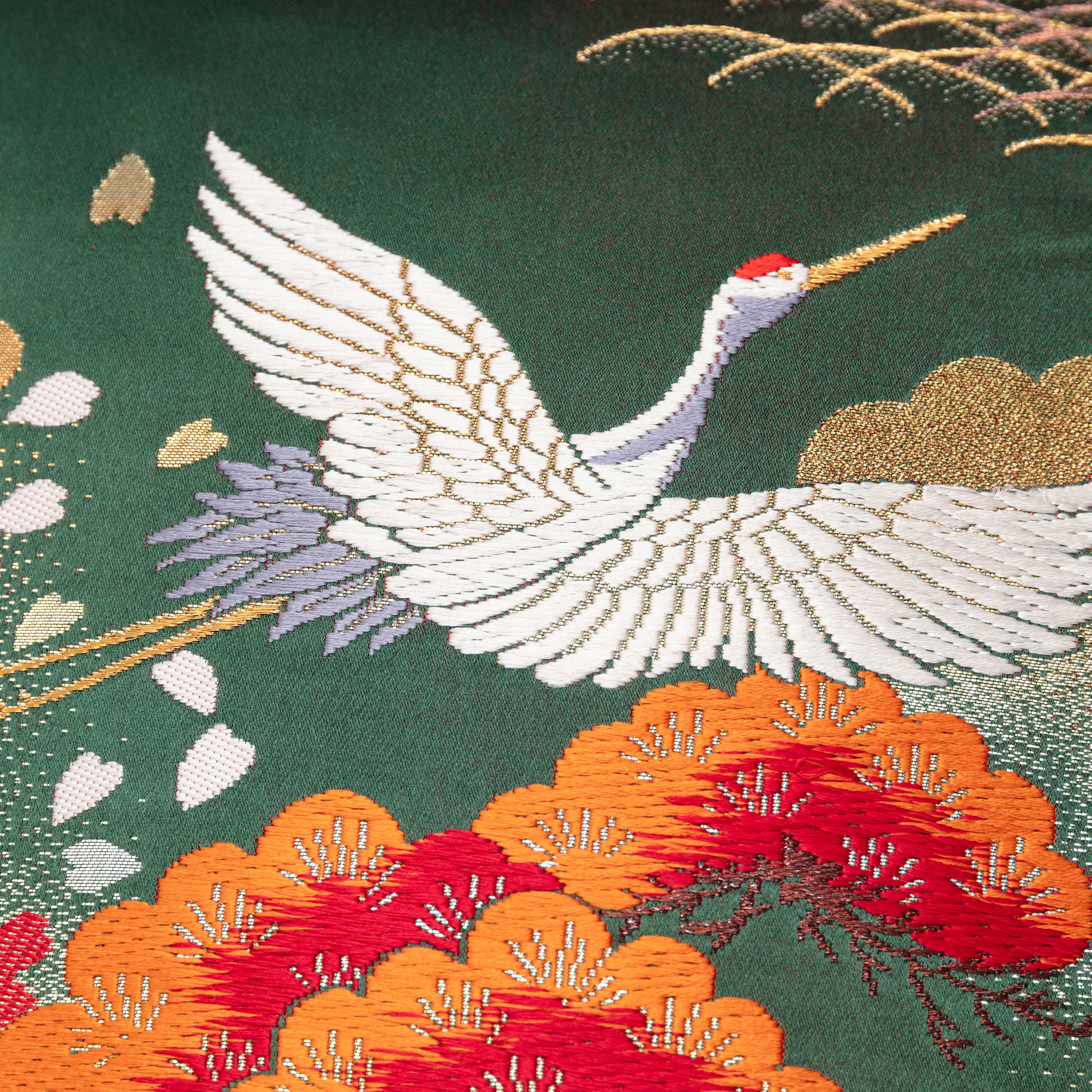 Dark green silk kimono pillow showing detail of white crane embroidery by Hunted and Stuffed, London.