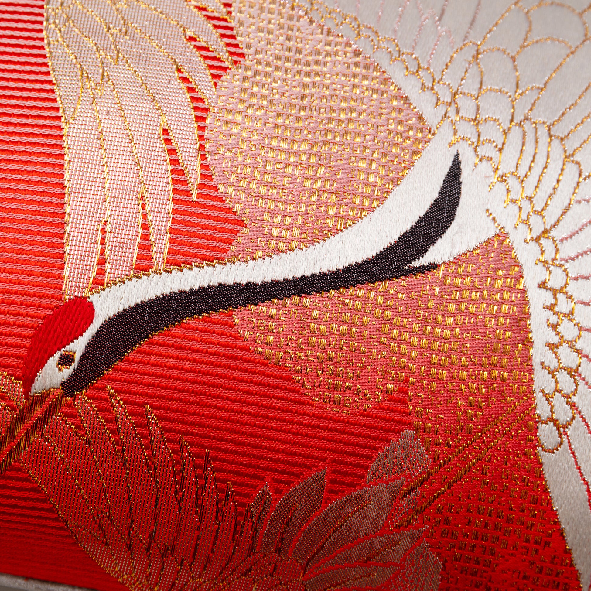 Detail of crane pillow in red silk and metallic gold.