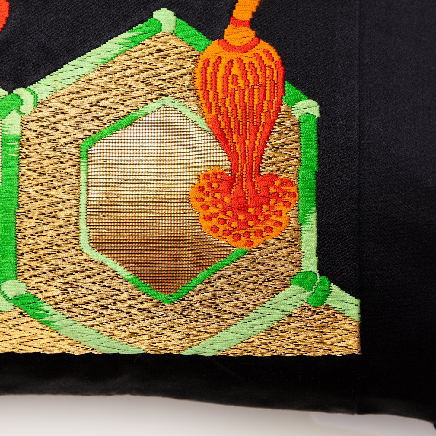 Woven metallic gold hexagons with green silk borders, detail from the front of the obi pillow.