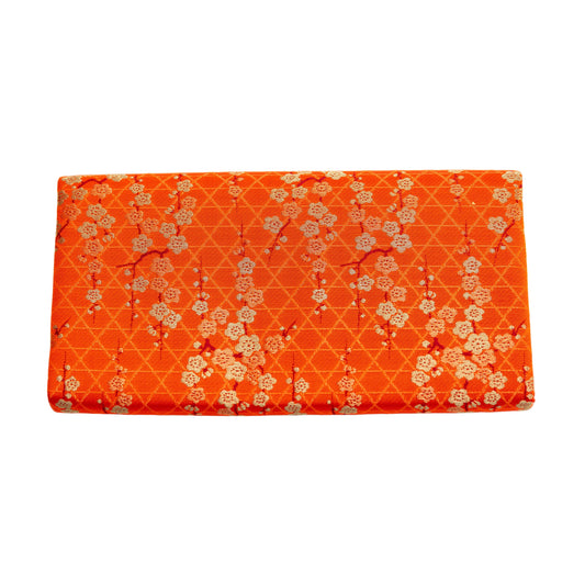 Orange silk vintage clutch bag with floral plum blossom pattern on a white background