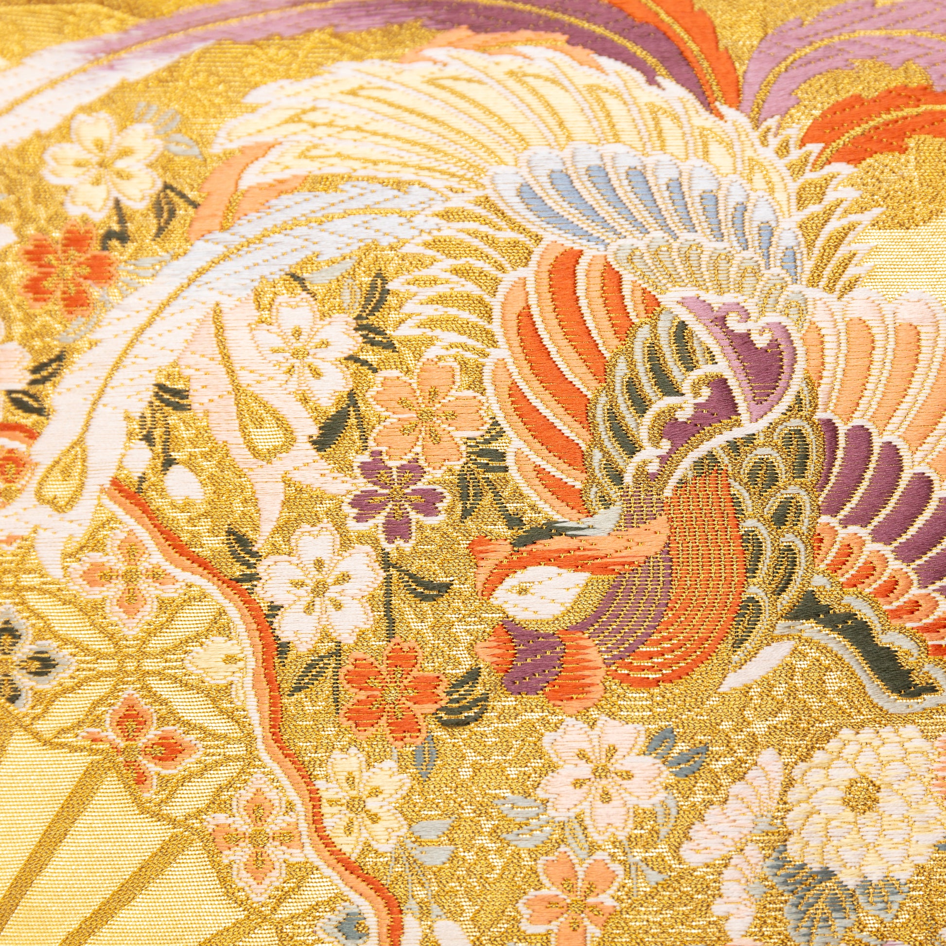 Detail of the central panel of the cushion showing a flying phoenix and flowers in woven gold, purple and orange silk.