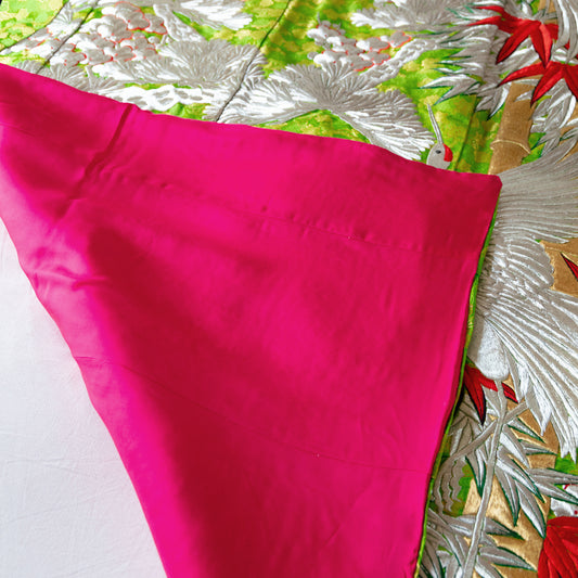 The reverse of the green silk throw is a plain bright pink silk