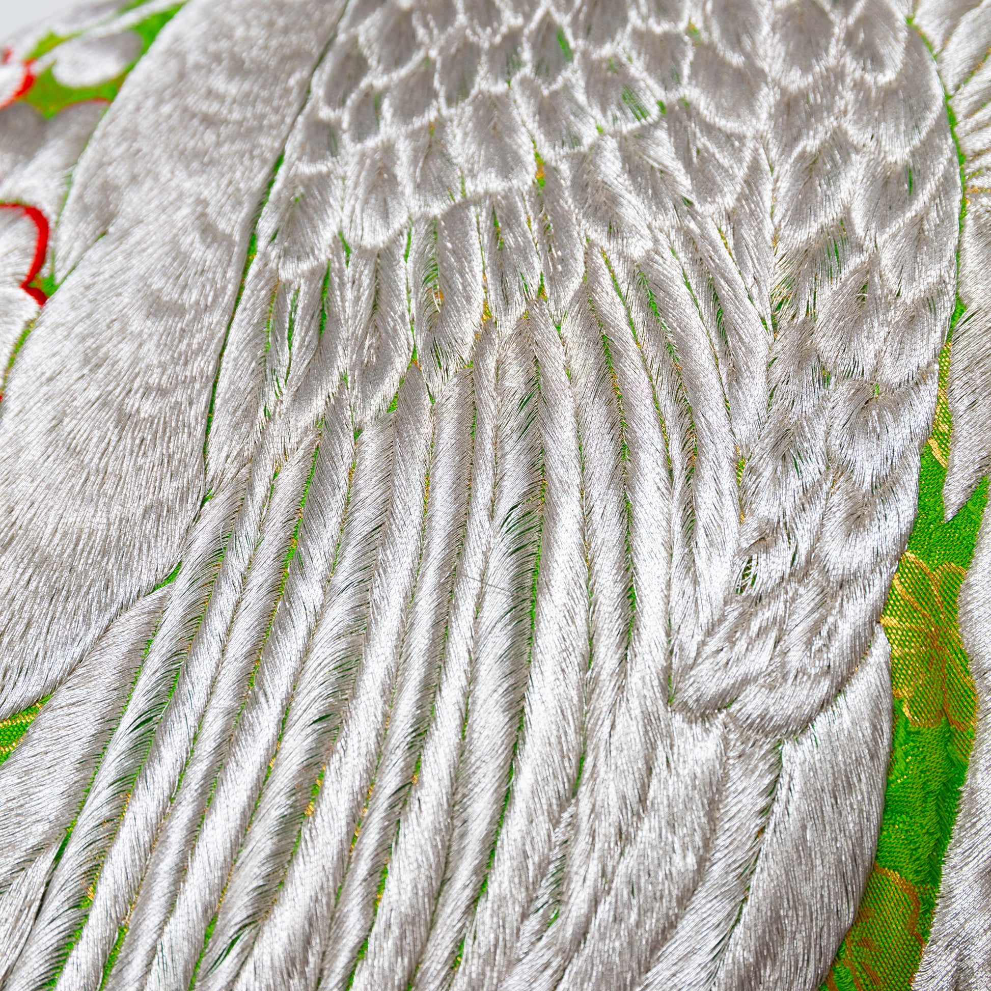 Silver feather embroidery pillow detail.