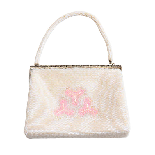 White bead vintage handbag with pink geometric design on a white background