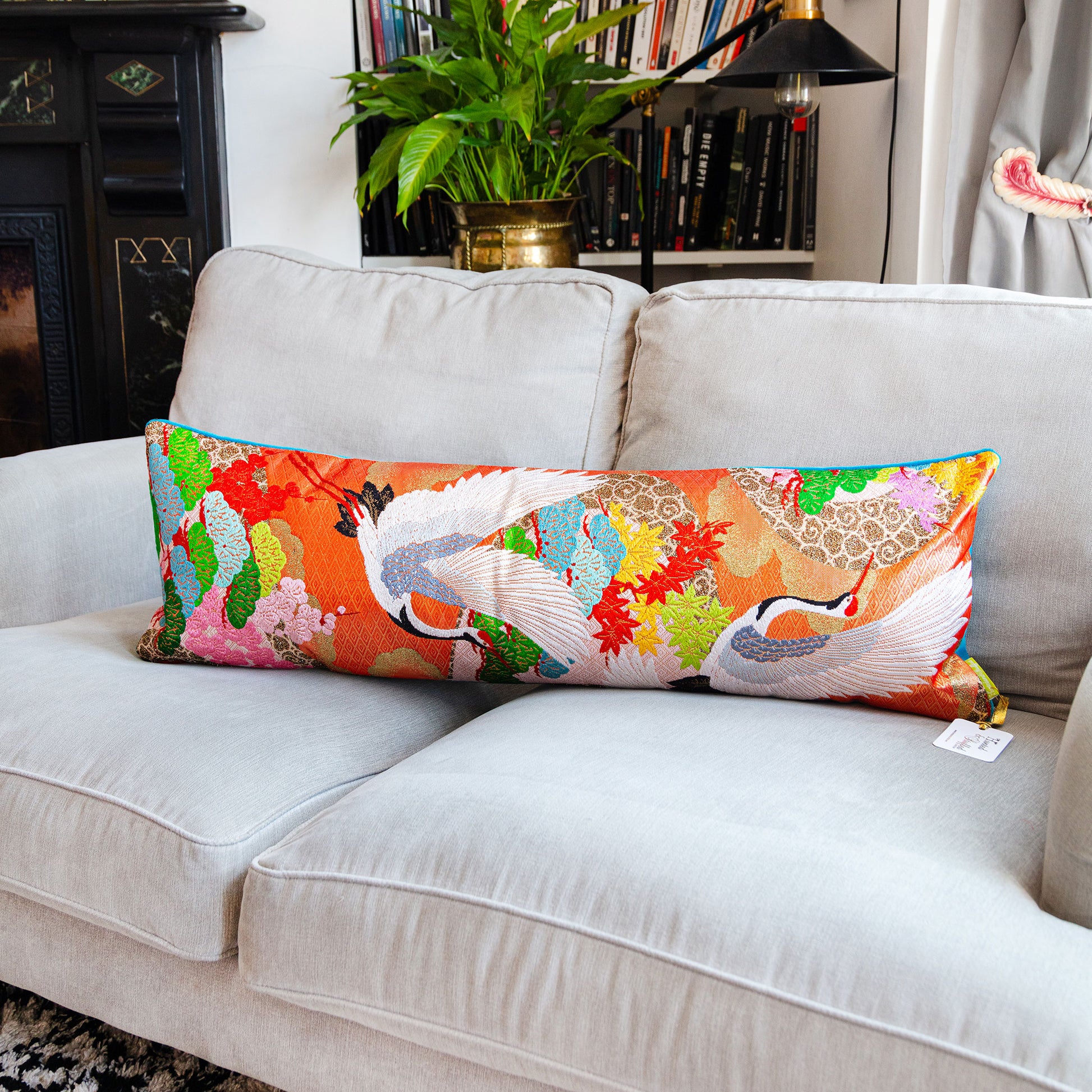 Long cranes bolster pillow with blue velvet back on grey sofa by Hunted and Stuffed