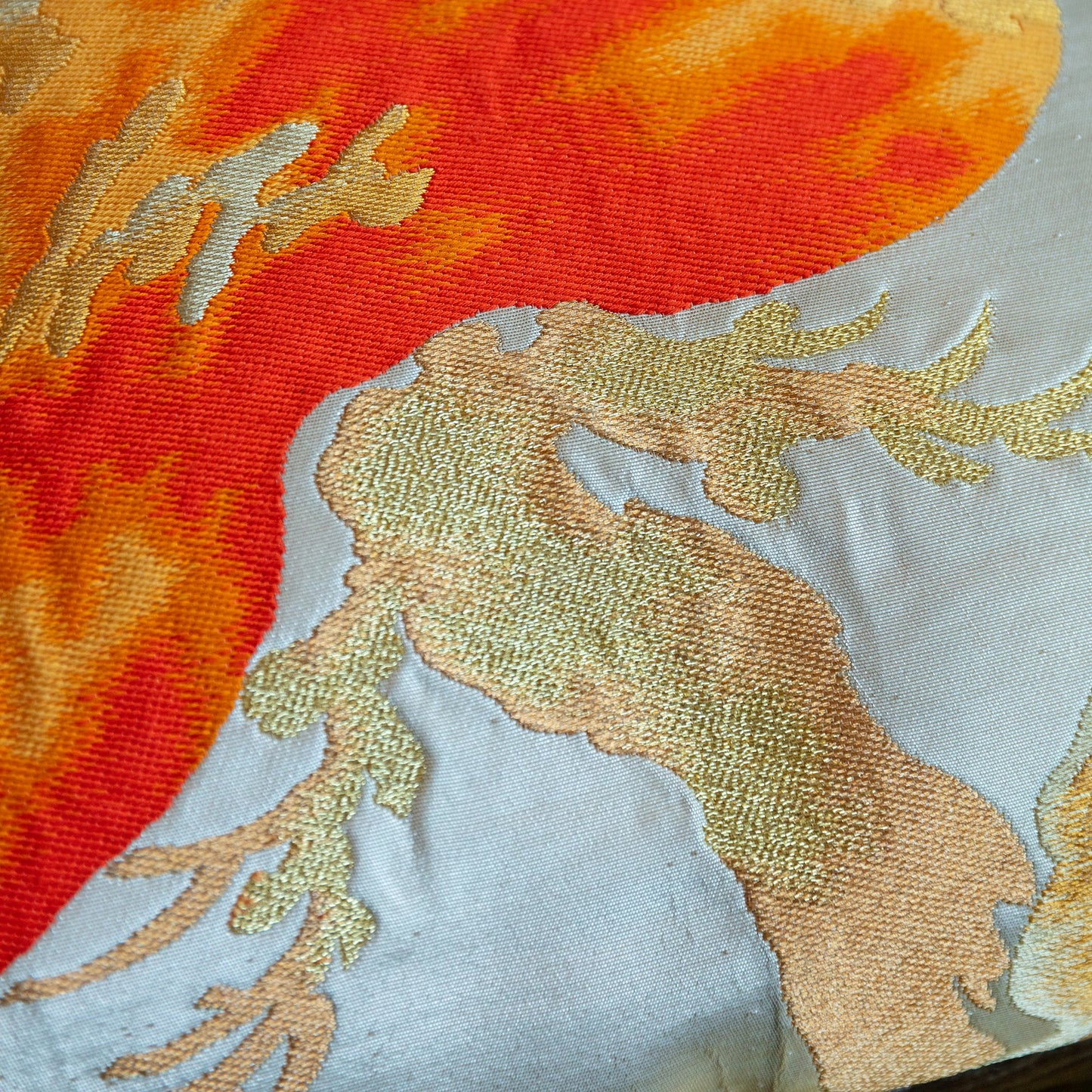 Antique Japanese obi pillow with orange pine tree motif close up detail.