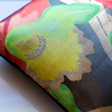 Japanese obi pillow detail with large flower design in yellow and green on black silk background. Black floral cushion by Hunted and Stuffed.
