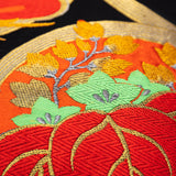 Detail of the obi silk pillow showing Kiri leaves and flowers in gold and red silk thread.