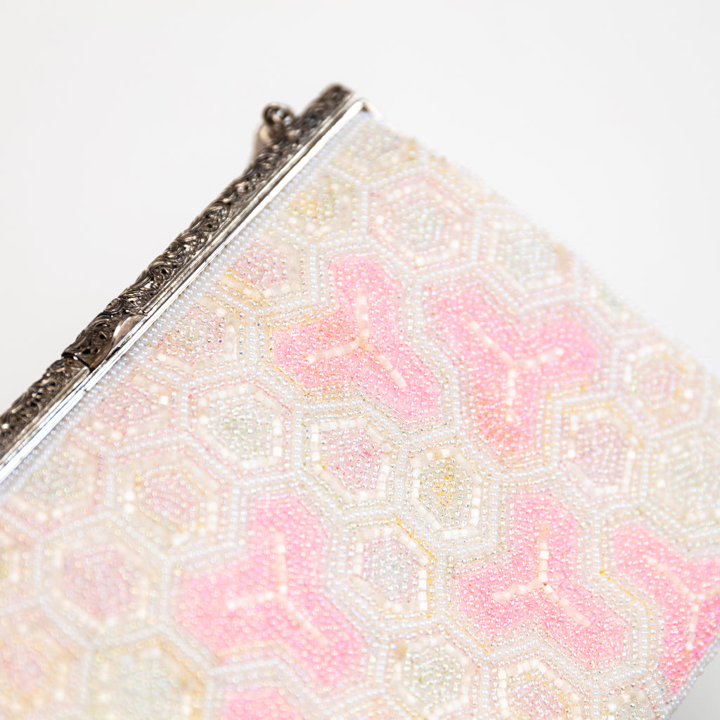 Close-up of intricate pink and white beadwork highlighting textured floral patterns on the vintage Japanese kimono clutch.
