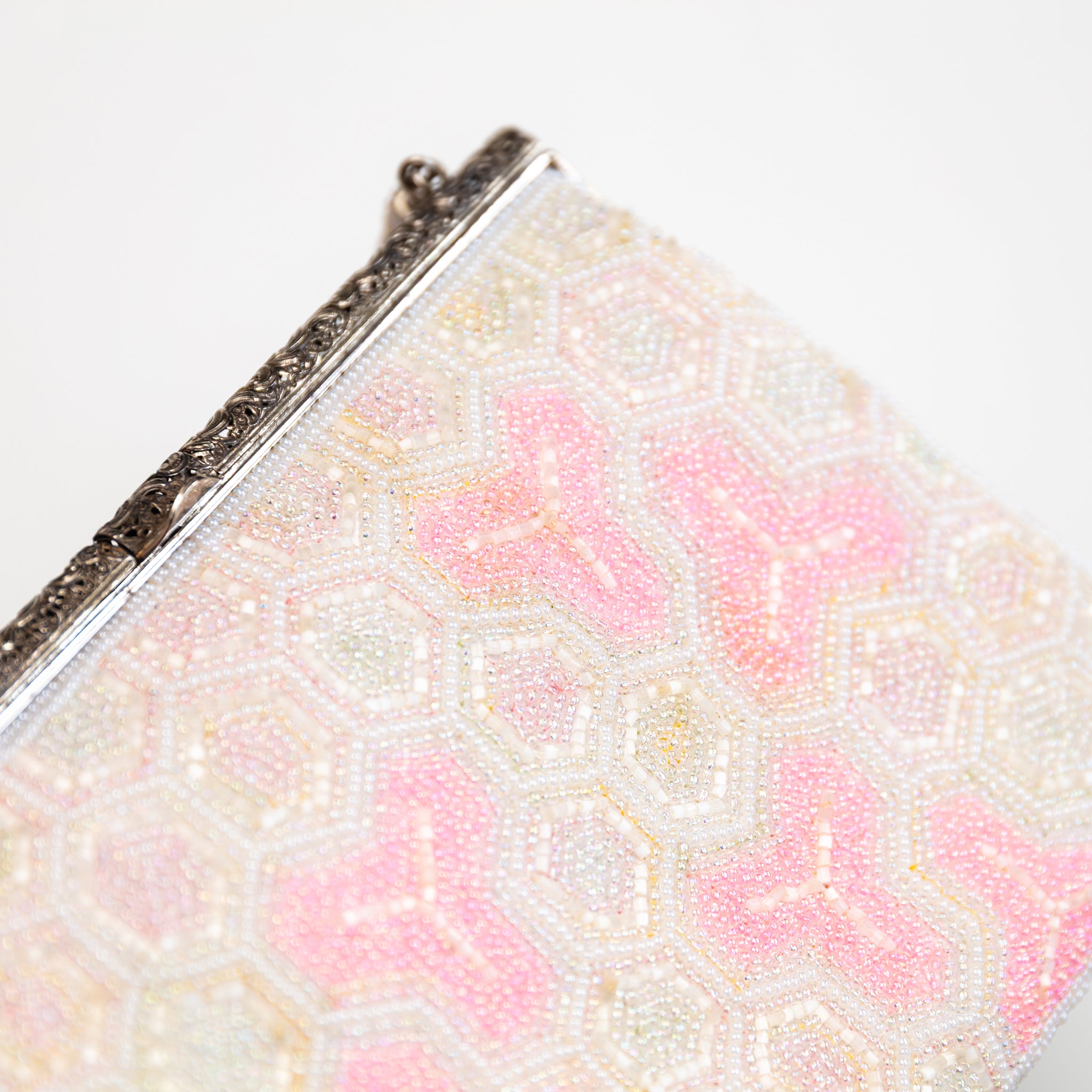 Close-up of intricate pink and white beadwork highlighting textured floral patterns on the vintage Japanese kimono clutch.
