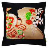 Black silk pillow made from vintage obi, central panel had gold drums and flowers with red and green accents.