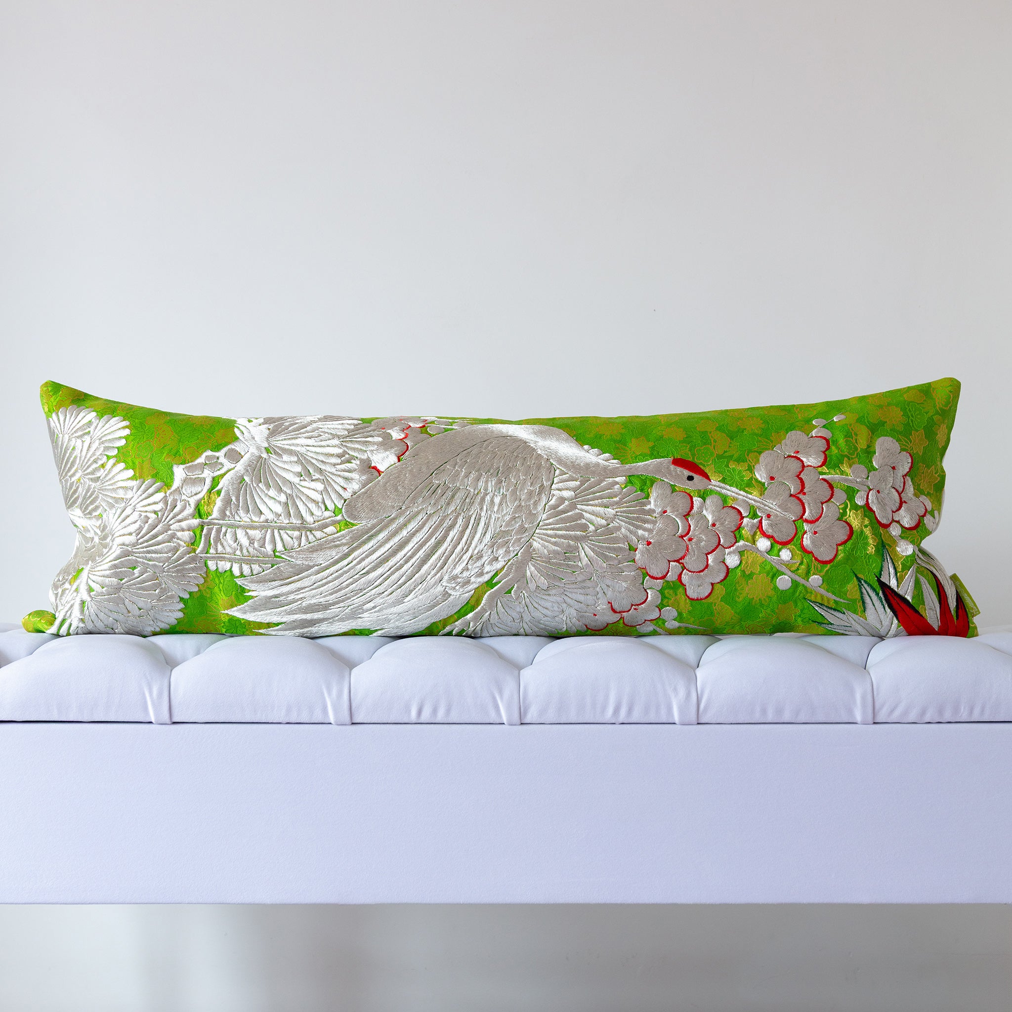 Green silk kimono bolster cushion with large embroidered silver crane and blossom branches, crafted from vintage Japanese silk