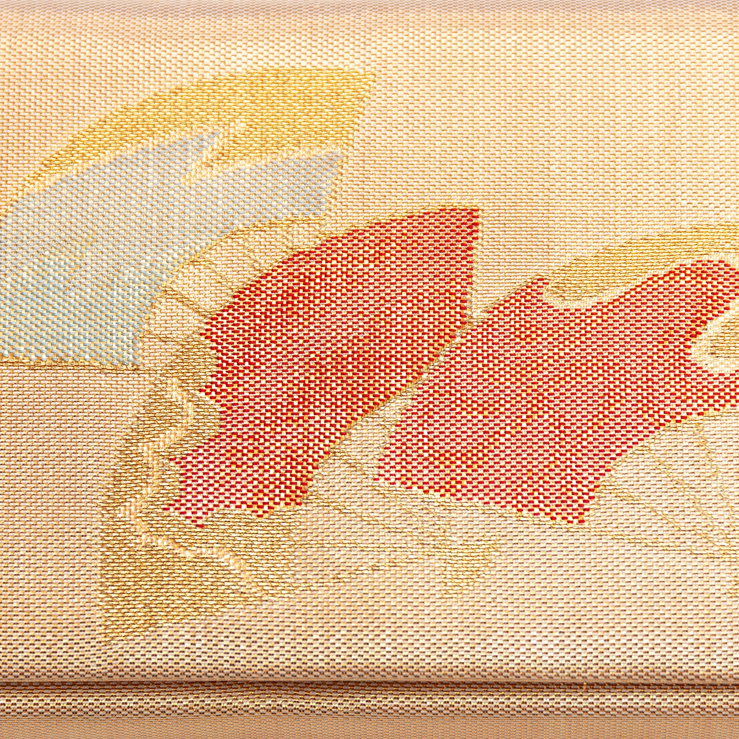 Close-up of the front design, woven metallic gold silk fabric with embroidered red and gold Japanese fans pattern