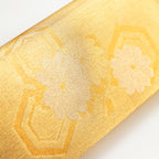 Close-up of textured gold metallic fabric with delicate floral embroidery on the foldover flap of the vintage kimono clutch