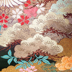 Close-up of the pink ombre fabric with embroidered cranes and floral details, highlighting the textured purple velvet edge