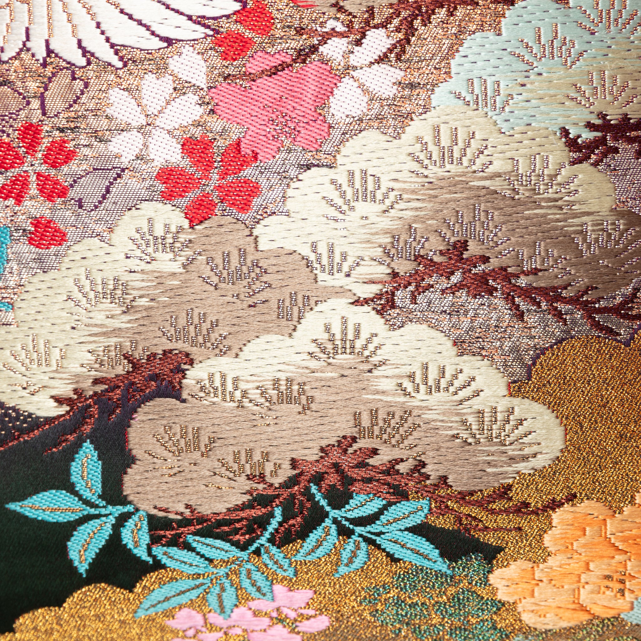 Close-up of the pink ombre fabric with embroidered cranes and floral details, highlighting the textured purple velvet edge