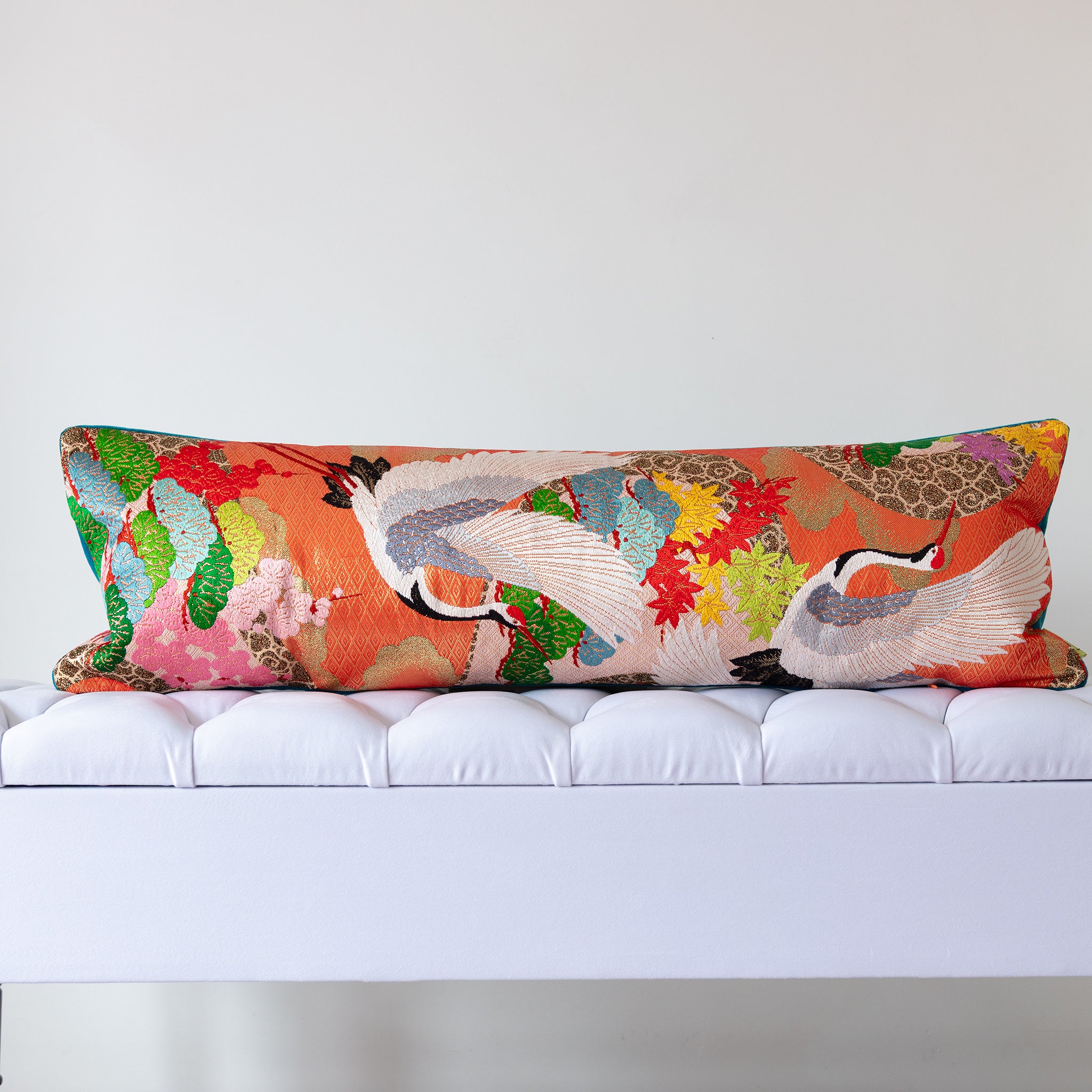 Orange silk kimono bolster cushion with white cranes and autumn maple leaves, crafted from vintage Japanese silk
