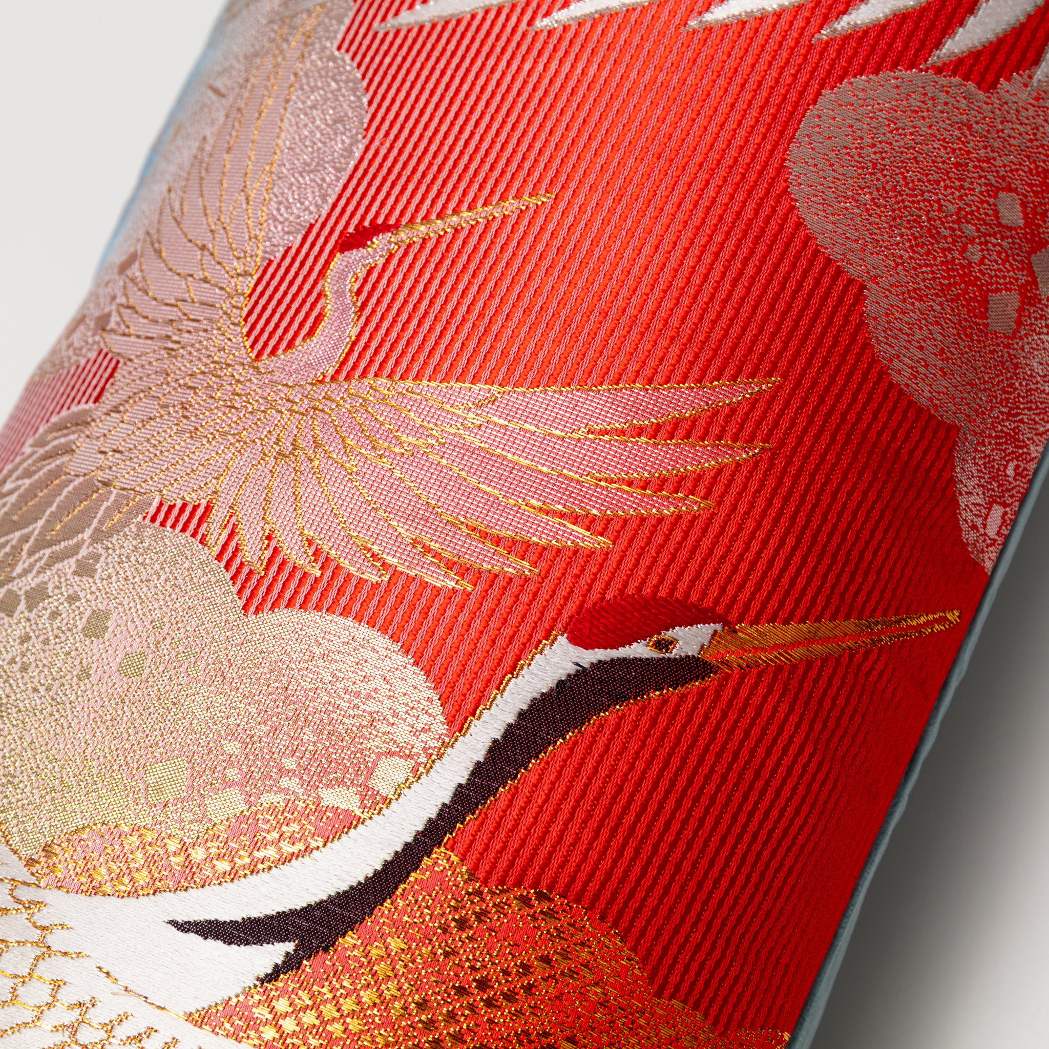 Close-up of vibrant red cranes embroidery and rich blue velvet fabric showing intricate stitching on the Kimono Silk Bolster
