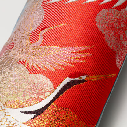 Detail of a pillow made by repurposing vintage wedding kimono silk with flying cranes pattern.