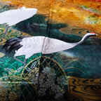 Close-up of multicoloured silk fabric showcasing intricate vintage kimono floral embroidery on the throw's textured surface.