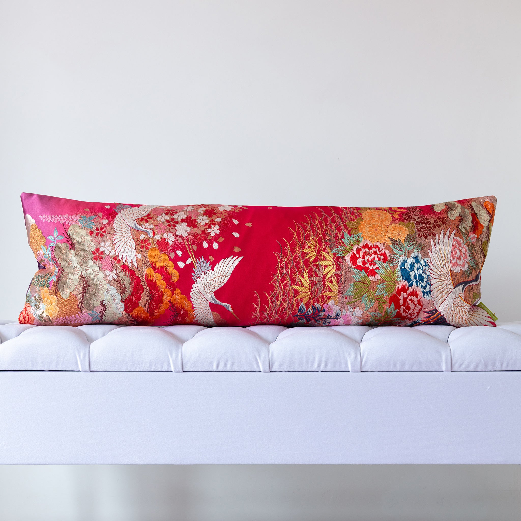 Bright red and gold silk kimono bolster cushion featuring cranes and layered florals, crafted from vintage Japanese silk