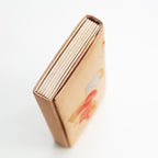 Close-up of gold silk fabric demonstrating intricate orange fan embroidery and subtle shimmering texture on the vintage