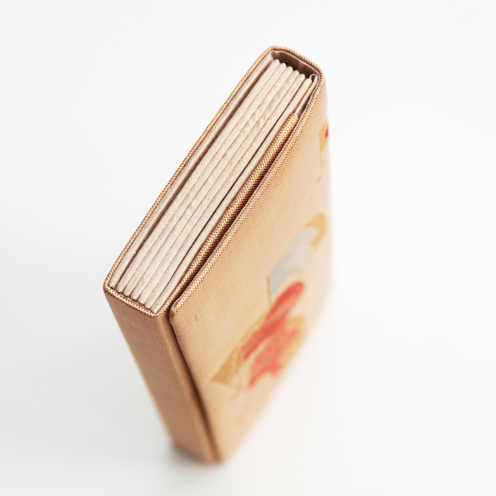 Close-up of the side of the vintage gold clutch bag on a white background