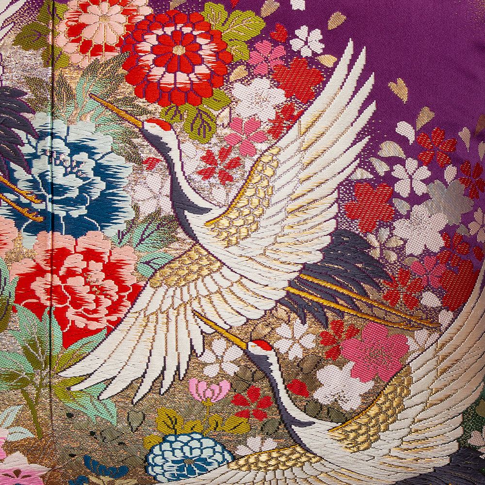 Embroidered design of cranes and flowers on a purple silk background, detail of upcycled vintage uchikake wedding kimono pillow.