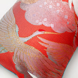 red pillow detail of flying crane in  gold over striped background silk.