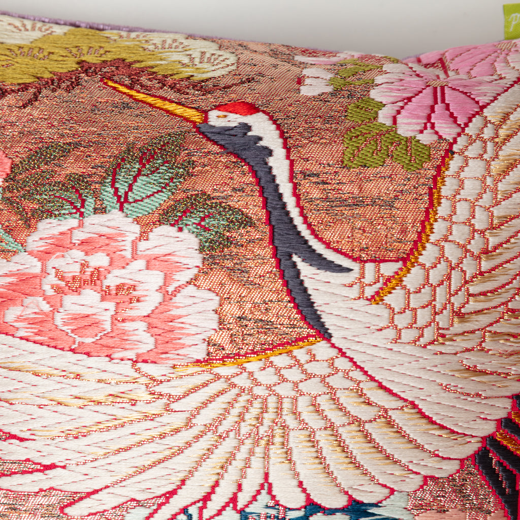 Close-up of the crimson fabric piping along the bolster's edge, highlighting the textured lilac velvet and intricate crane