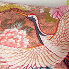 Close-up of the crimson fabric piping along the bolster's edge, highlighting the textured lilac velvet and intricate crane