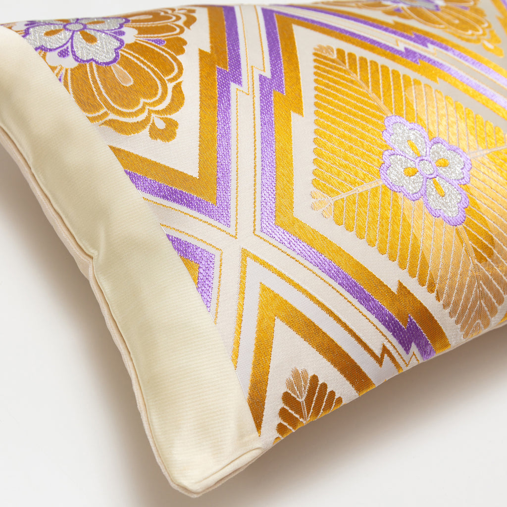 Close-up of the gold diamond embroidery on the purple fabric with visible texture and intricate stitching details.