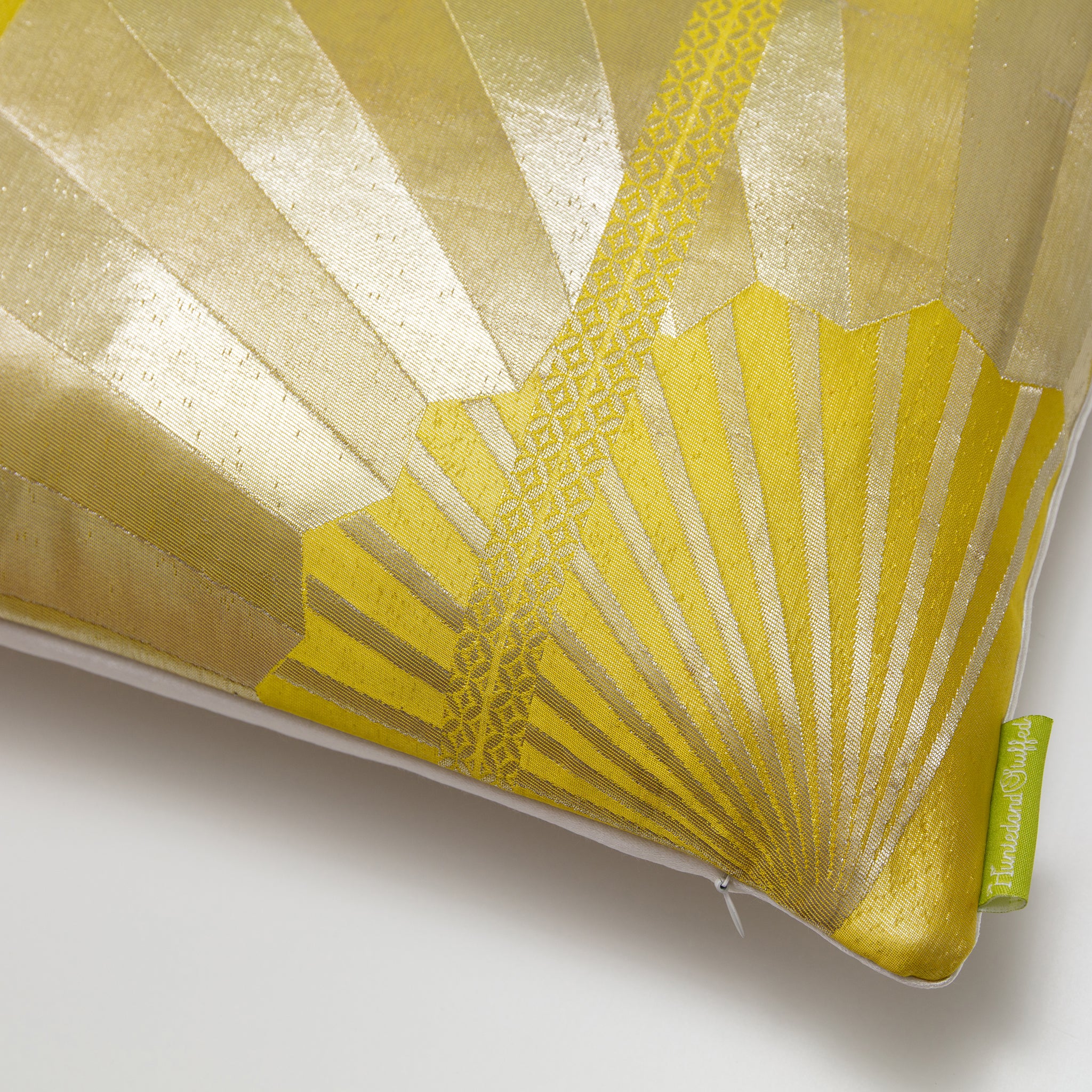 Close-up of the gold fans pattern and textured silk weave on the vintage obi-inspired green silk pillow showcasing intricate
