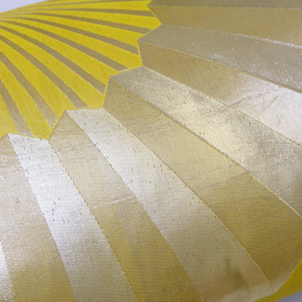Close-up of the pillow's golden fan pattern stitched onto chartreuse silk, highlighting intricate embroidery and rich