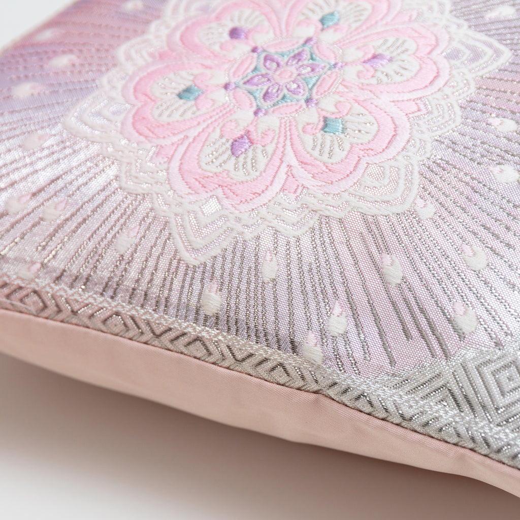 Close-up of the pink ombre silk fabric showcasing silver floral hexagon embroidery and textured stripe details on the Obi