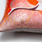 Close-up of the Rising Crane Peachy Red Silk pillow's textured silk surface with taupe velvet piping, showcasing intricate