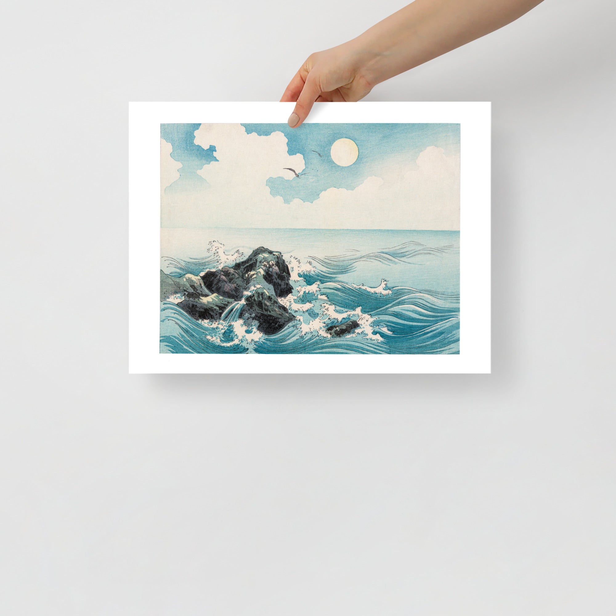 Close-up of textured woodgrain and subtle ink detail highlighting waves crashing on rocks in the Japanese woodcut print.