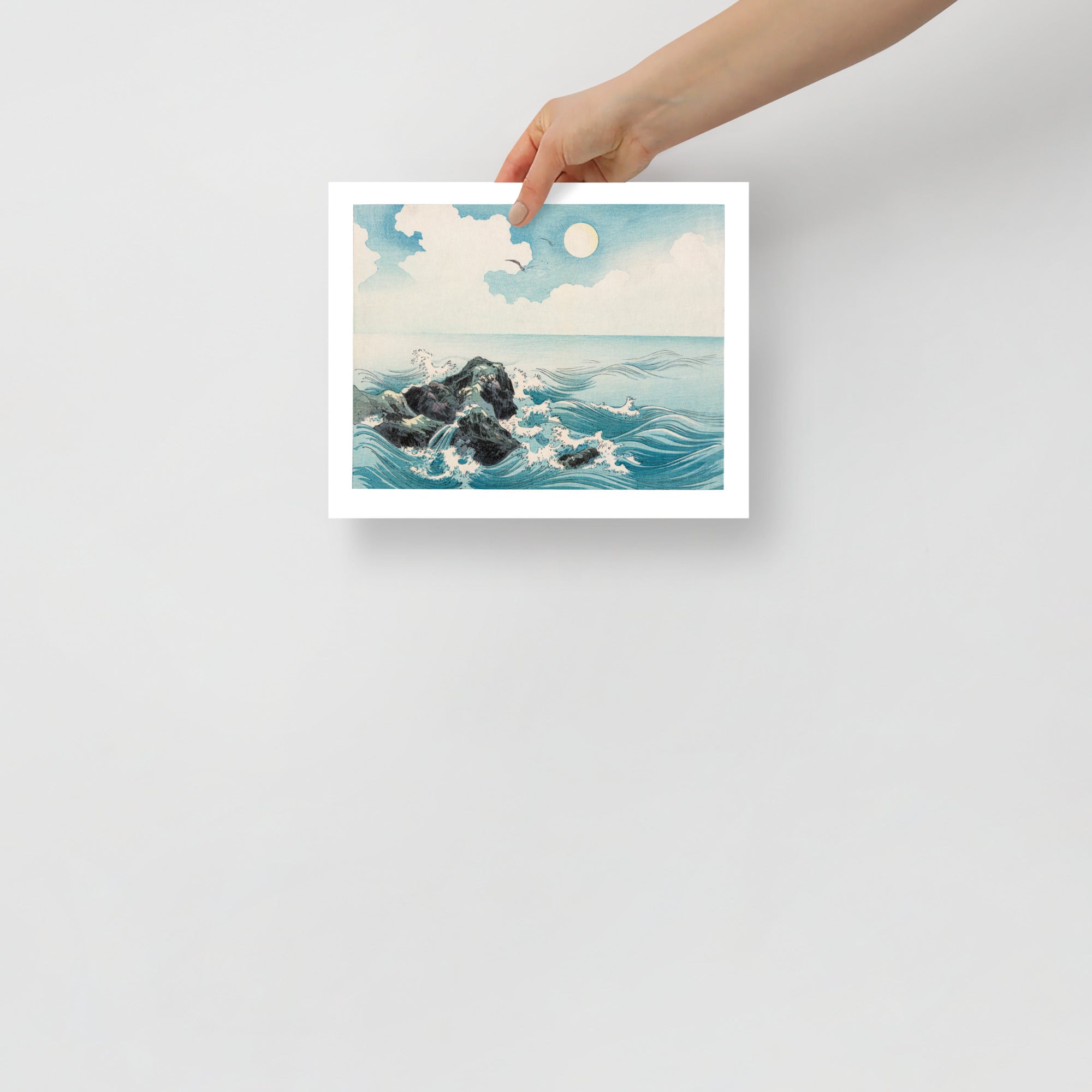 Detail of waves crashing onto jagged rocks, highlighting textured woodcut lines and dynamic motion in the Japanese print.