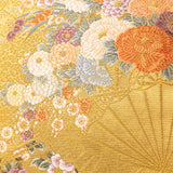 Deatil of the golden fans and the white, blue, orange and purple silk thread woven flowers.
