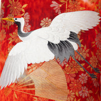 Detail of a red Japanese vintage kimono pillow with white flying crane