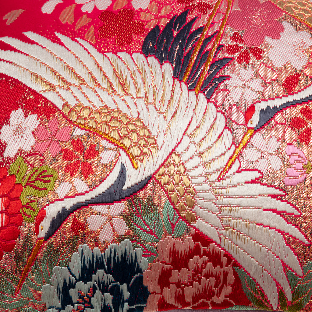 Close-up of the red gold cranes and lilac velvet fabric showing intricate embroidered floral patterns and rich textures