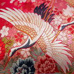 Close-up of the red gold cranes and lilac velvet fabric showing intricate embroidered floral patterns and rich textures