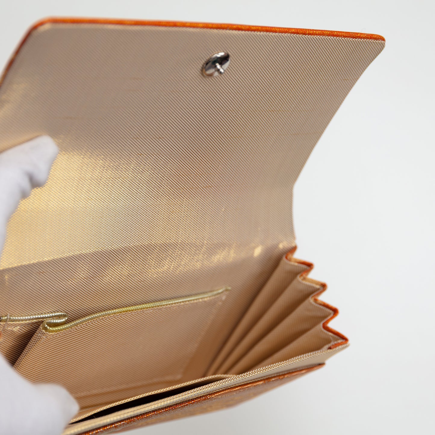View inside the vintage Japanese clucth bag showing gold lining silk, internal pocket with gold trim and metal fastener.