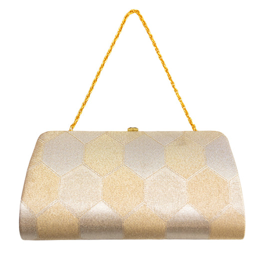 Gold and pale gold hexagonal patterned clutch bag with a gold metal strap on a white background