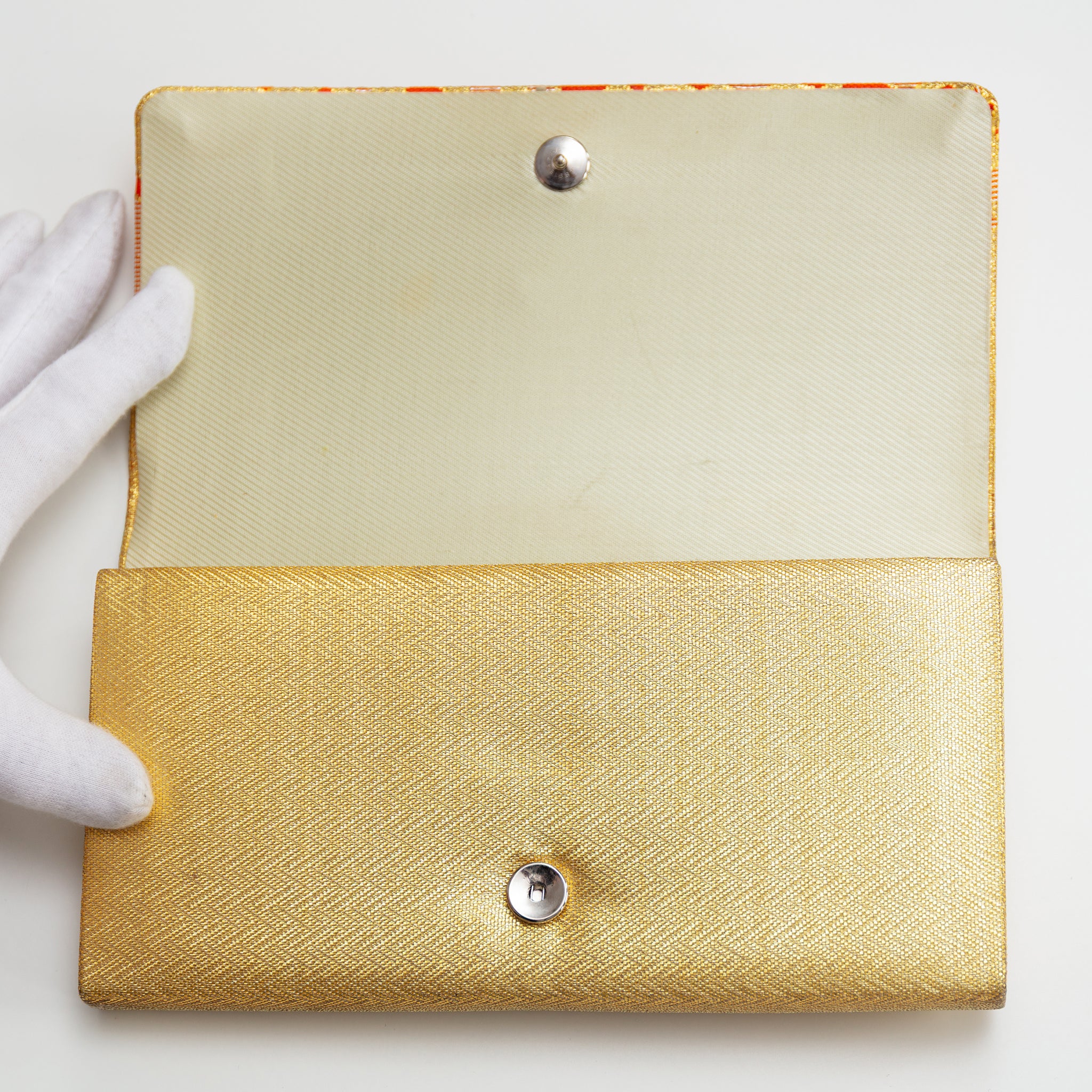 Close-up of the textured gold silk fabric highlighting orange diamond patterns and intricate stitching detail on the vintage