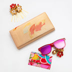 Close-up of the textured gold silk surface highlighting vibrant orange fan embroidery and intricate stitching detail.