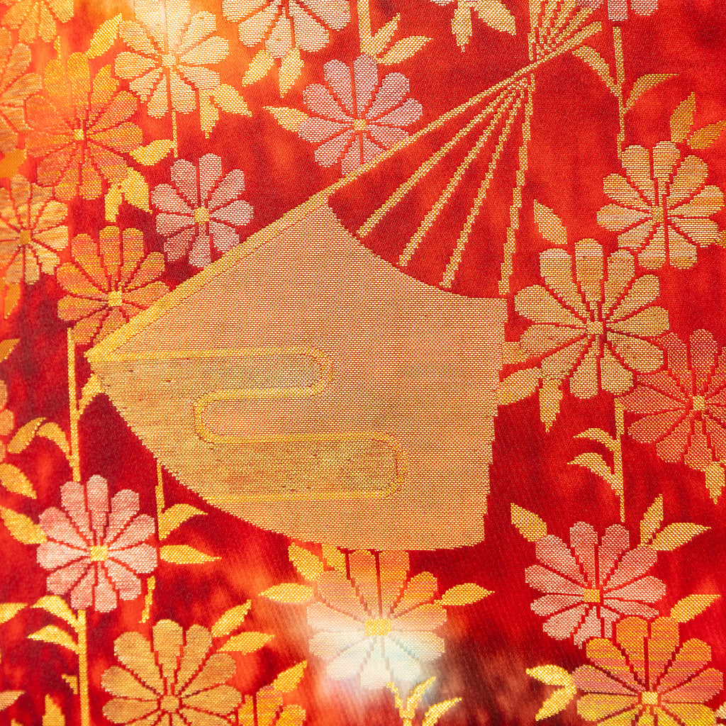 Close-up of the intricate gold silk embroidery and flying crane motif on the bolster pillow's corner, highlighting