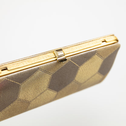 Gold clutch with geometric pattern on a white background